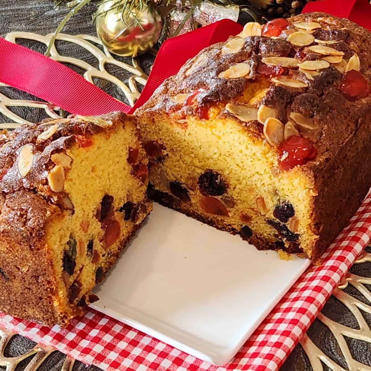 Vanilla Fruit Cake sliced into two on a white plate.