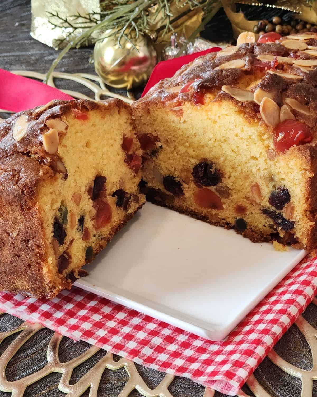 Vanilla Fruit Cake sliced into two on a white plate.