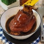 Glossy, tender braised pork shank served in a bowl.