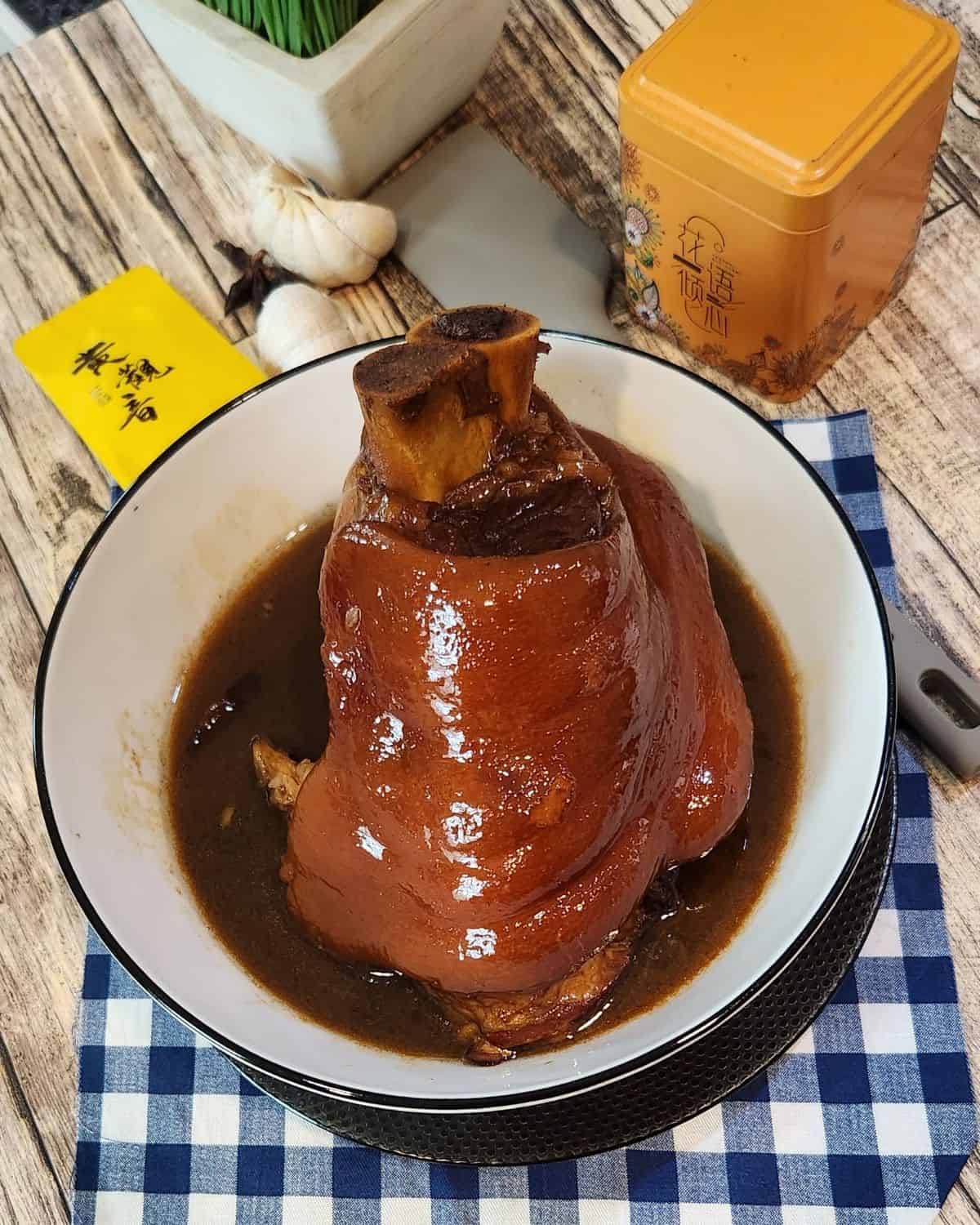 Glossy, tender braised pork shank served in a bowl.