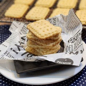 A stack of cheese cookies on a ruffled parchment paper.