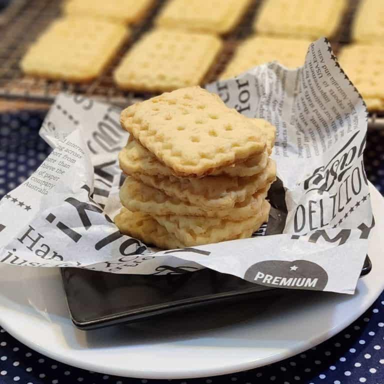 A stack of cheese cookies on a ruffled parchment paper.