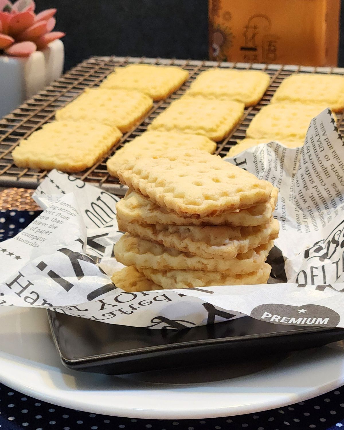 A stack of cute cheese cookies on a parchment paper with some on wire rack.