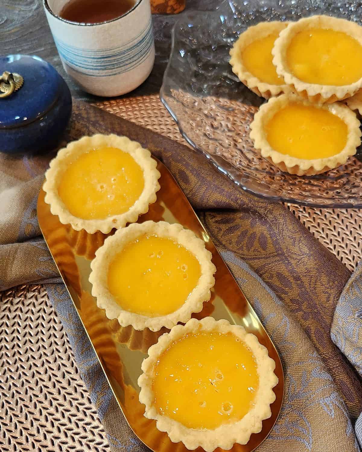 Hong Kong style egg tarts on a golden plate.