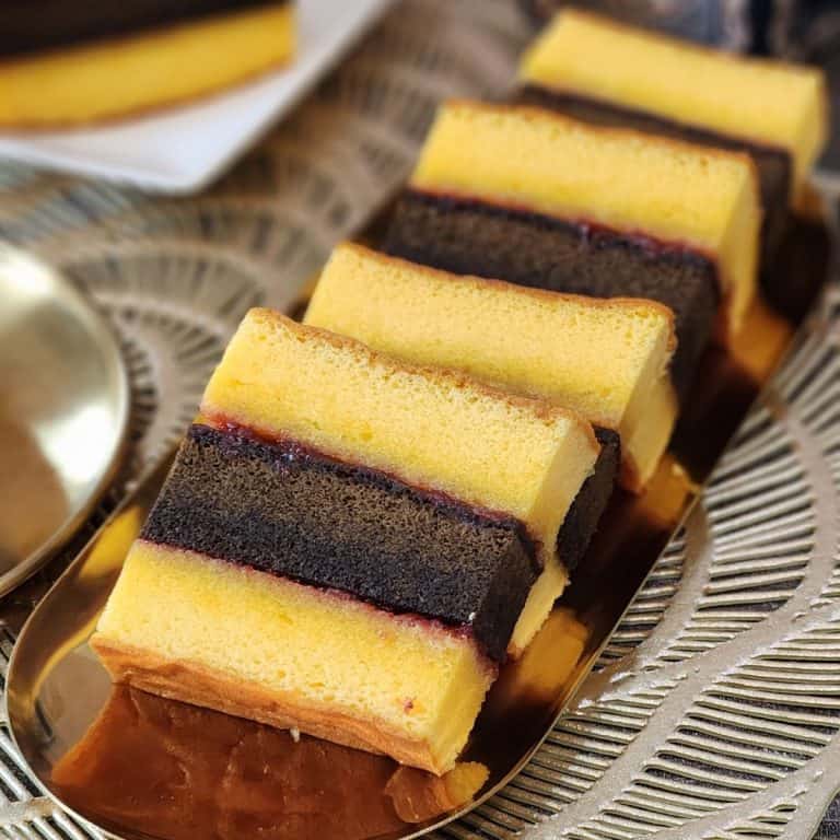 A few slices of Lapis Surabaya cake on a golden plate.