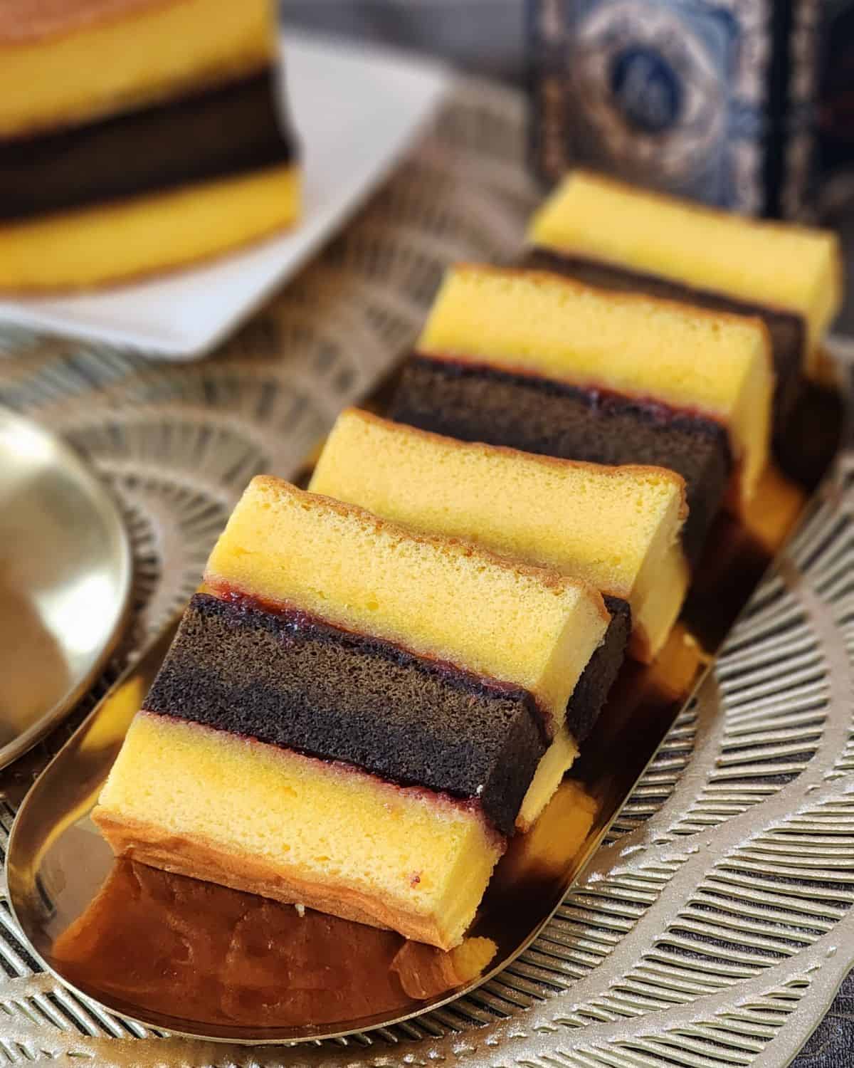 A few slices of Lapis Surabaya cake on a golden plate.