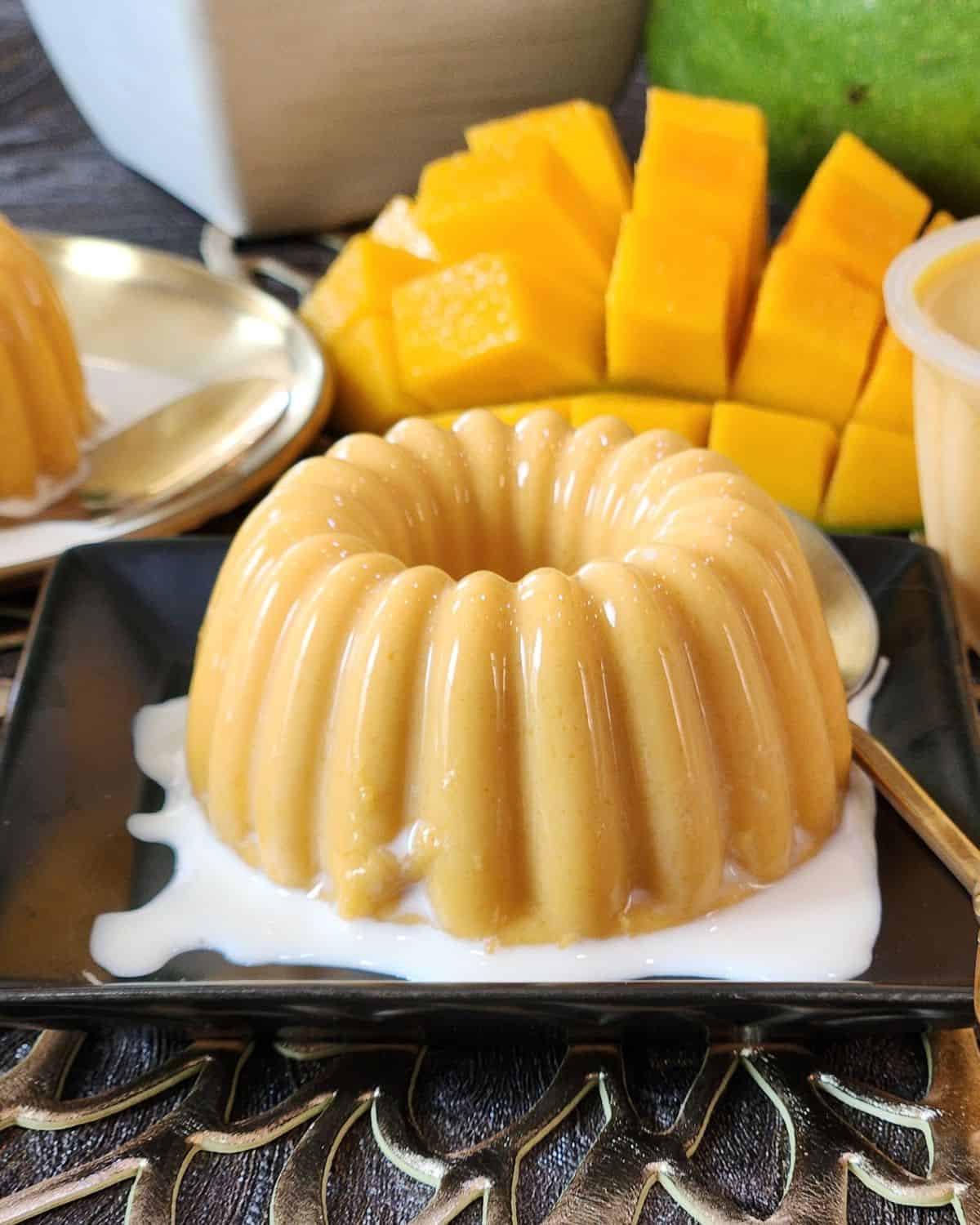A small plate with mango pudding and evaporated milk.