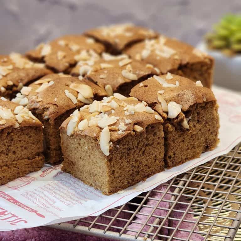 Several Dutch ontbijtkoek slices on parchment paper and wire rack.