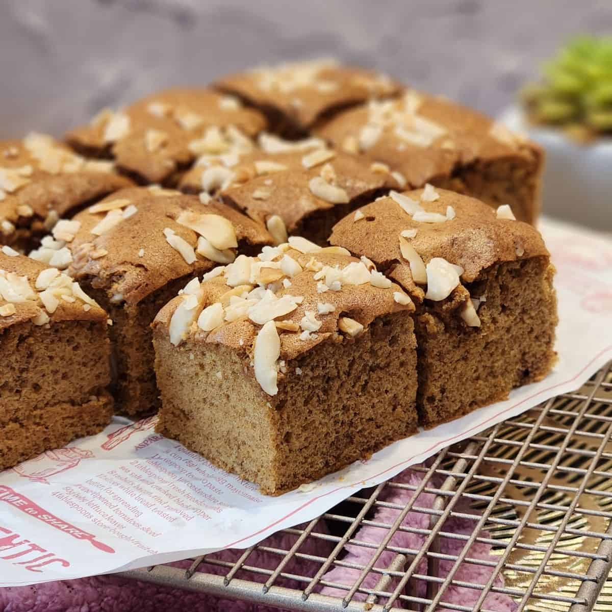Several Dutch ontbijtkoek slices on parchment paper and wire rack.