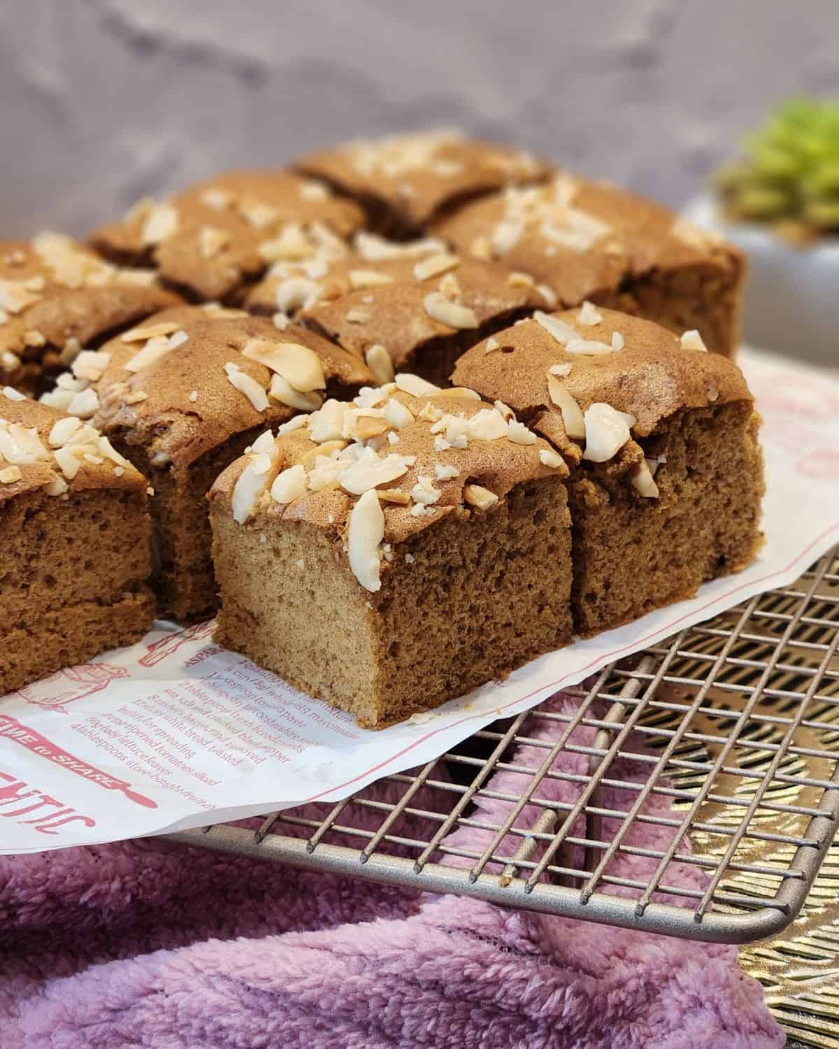 Several Dutch ontbijtkoek slices on parchment paper and wire rack.