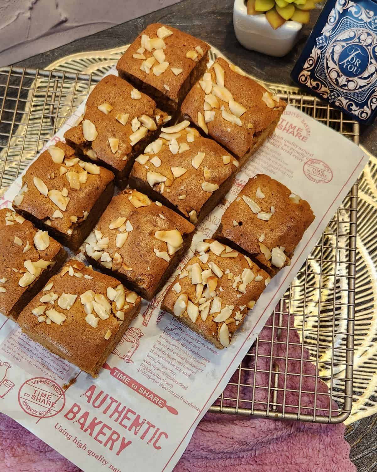 Several Dutch ontbijtkoek slices on parchment paper and wire rack.