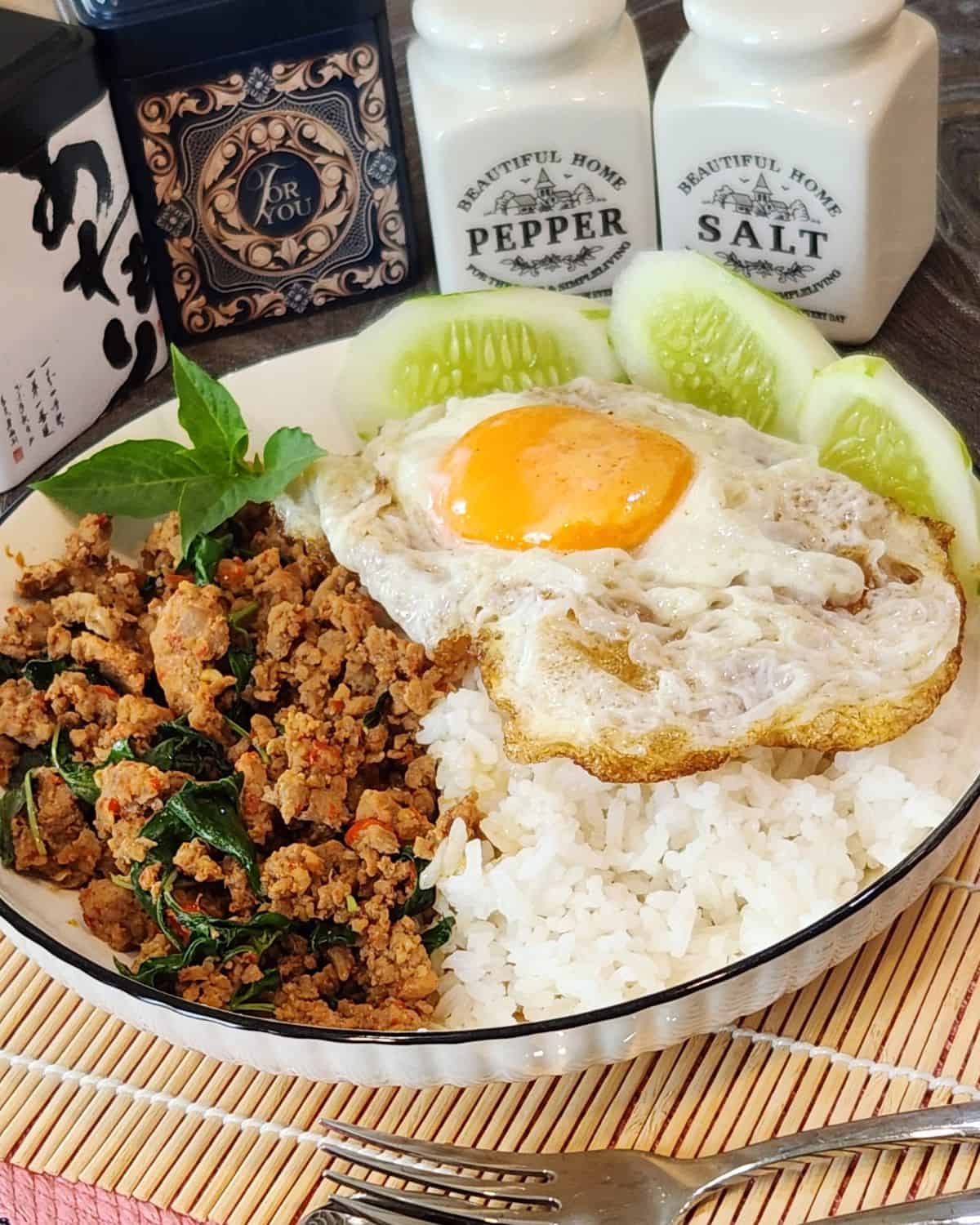 A plate of pad kra pao with rice and crispy fried egg.
