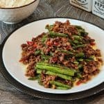 A plate of green beans and ground beef stir fry.