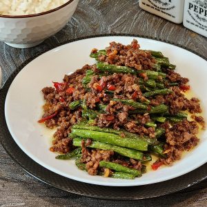 A plate of green beans and ground beef stir fry.