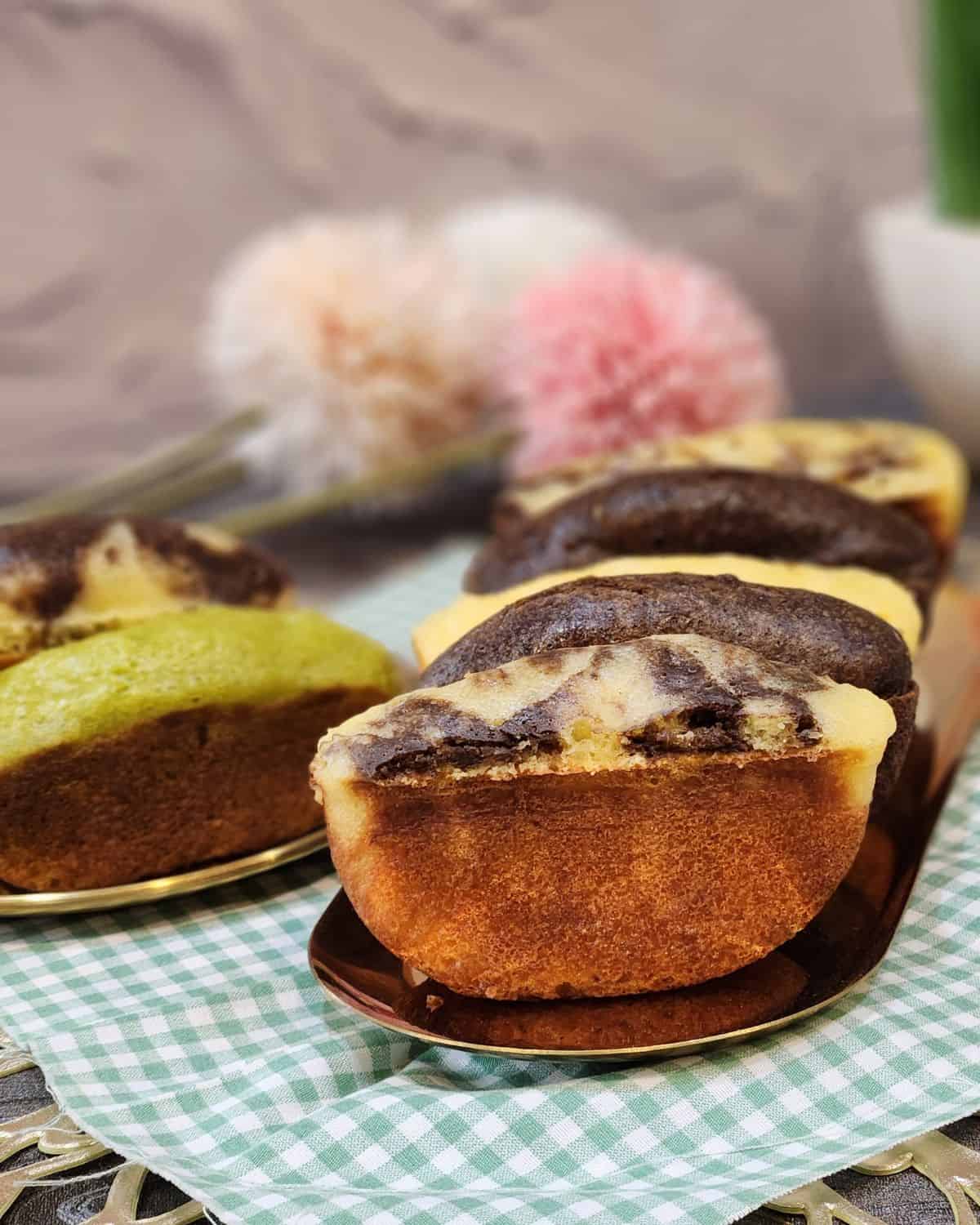 A few chocolate and pandan pukis on a golden tray.