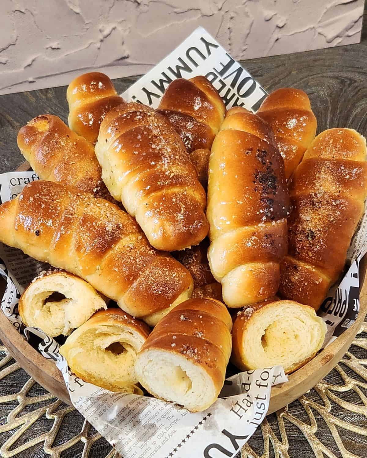 A stack of Salt Bread in a wooden basket. 