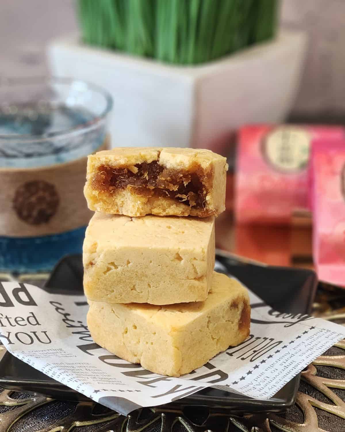 A stack of three Taiwanese pineapple cakes with pineapple jam filling inside. 