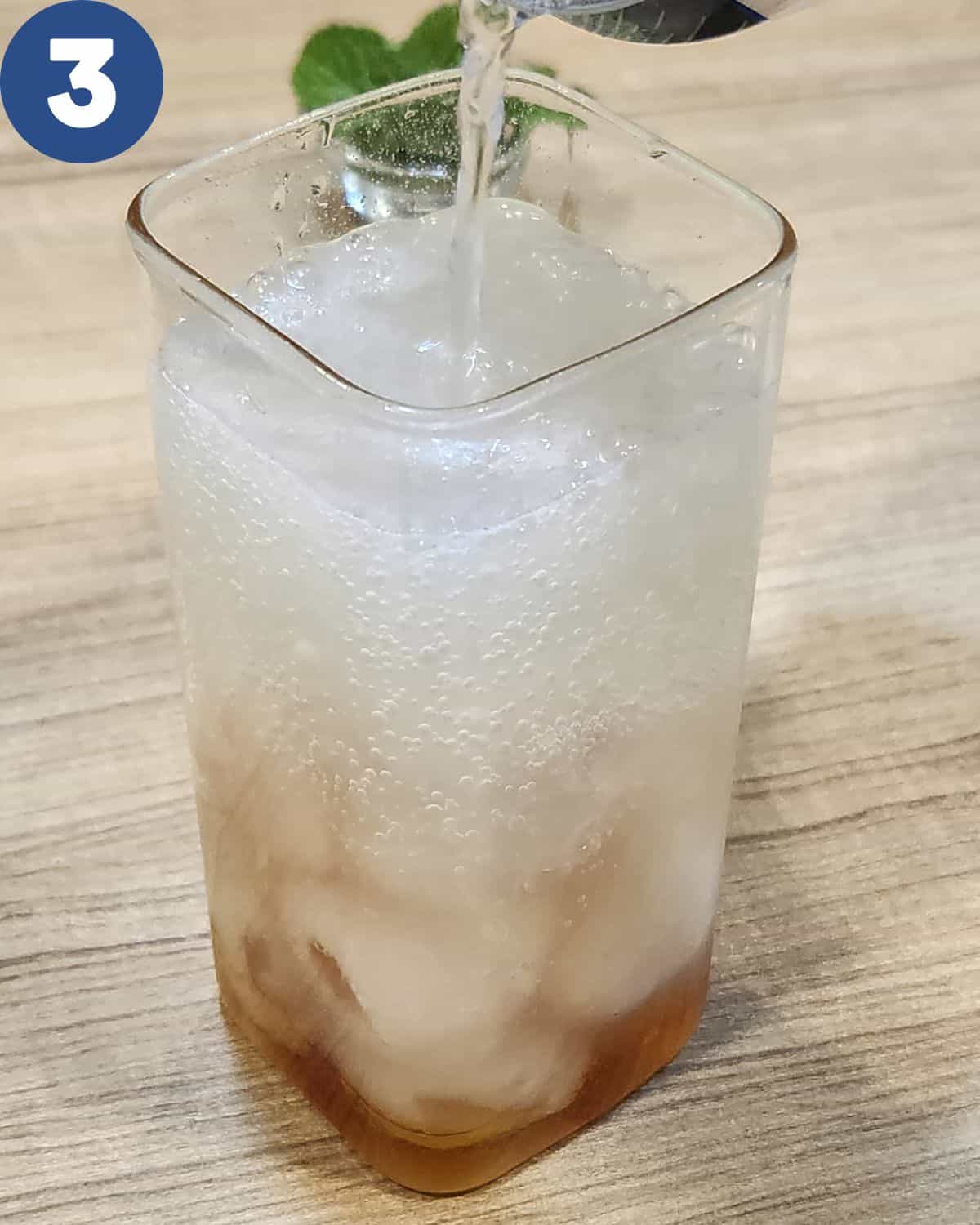 Pouring soda water into the serving glass.
