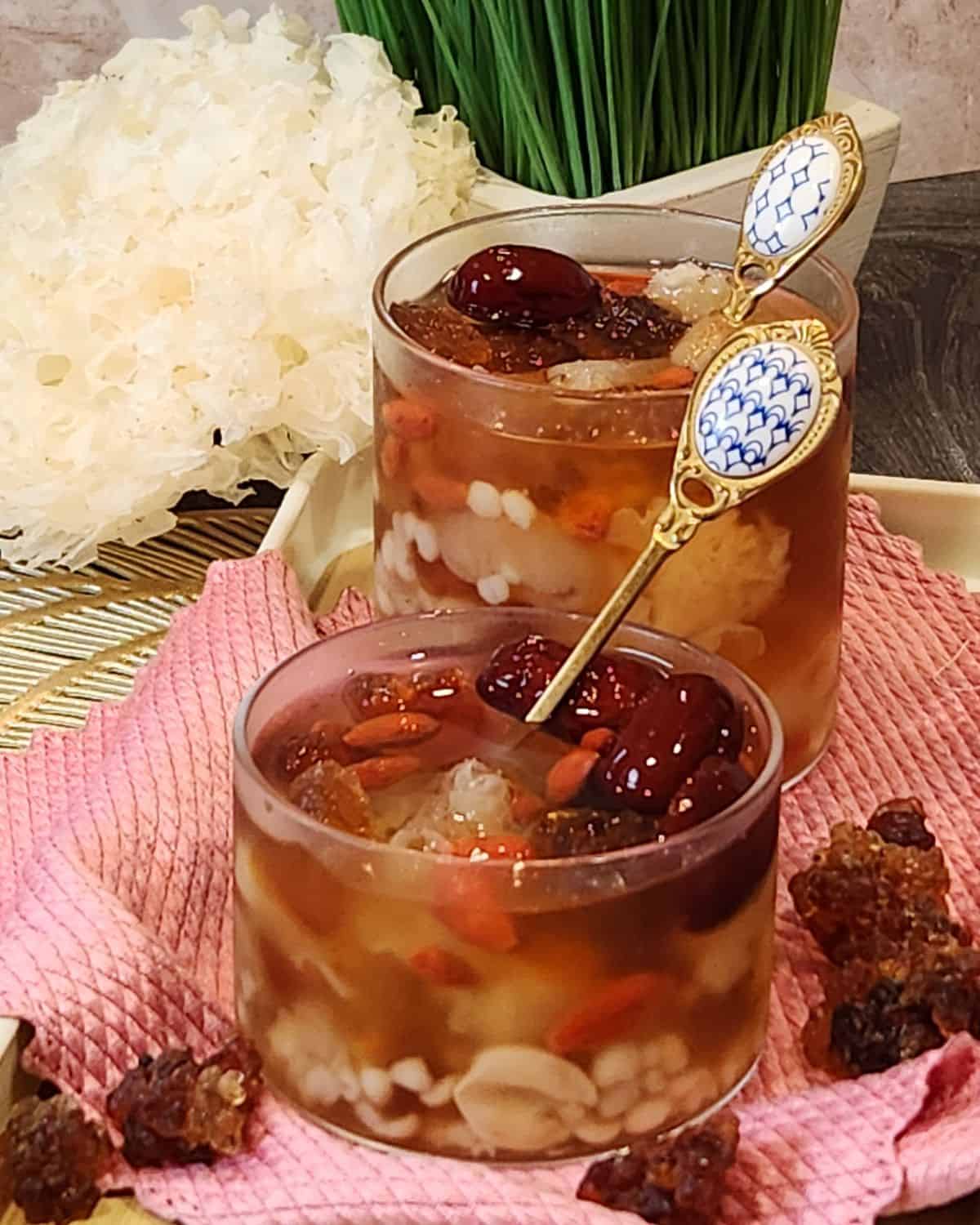 A glass of peach gum dessert (tong sui) or snow fungus dessert served cold on a tray.