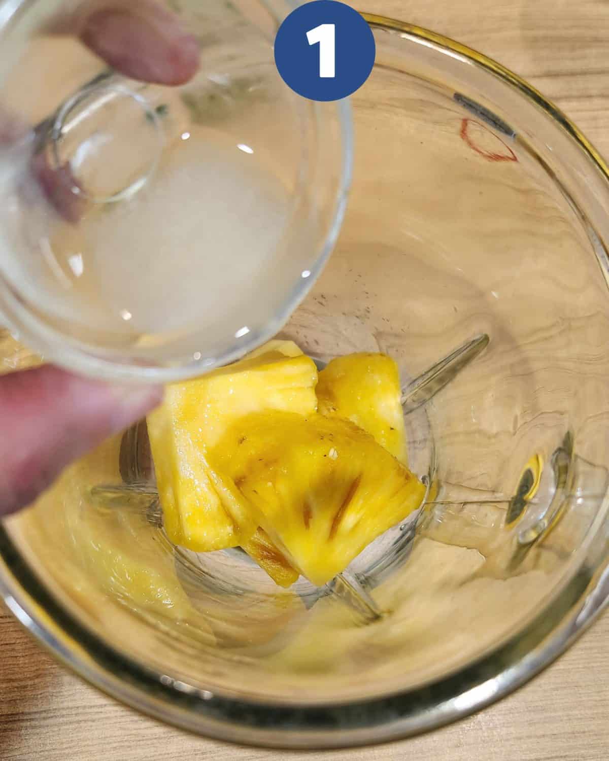 Blending pineapple slices with lime juice.