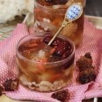 A glass of peach gum dessert (tong sui) or snow fungus dessert served cold on a tray.