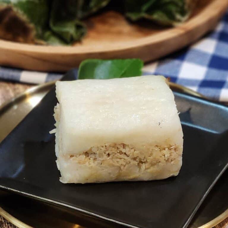 A small black plate with lemper ayam.