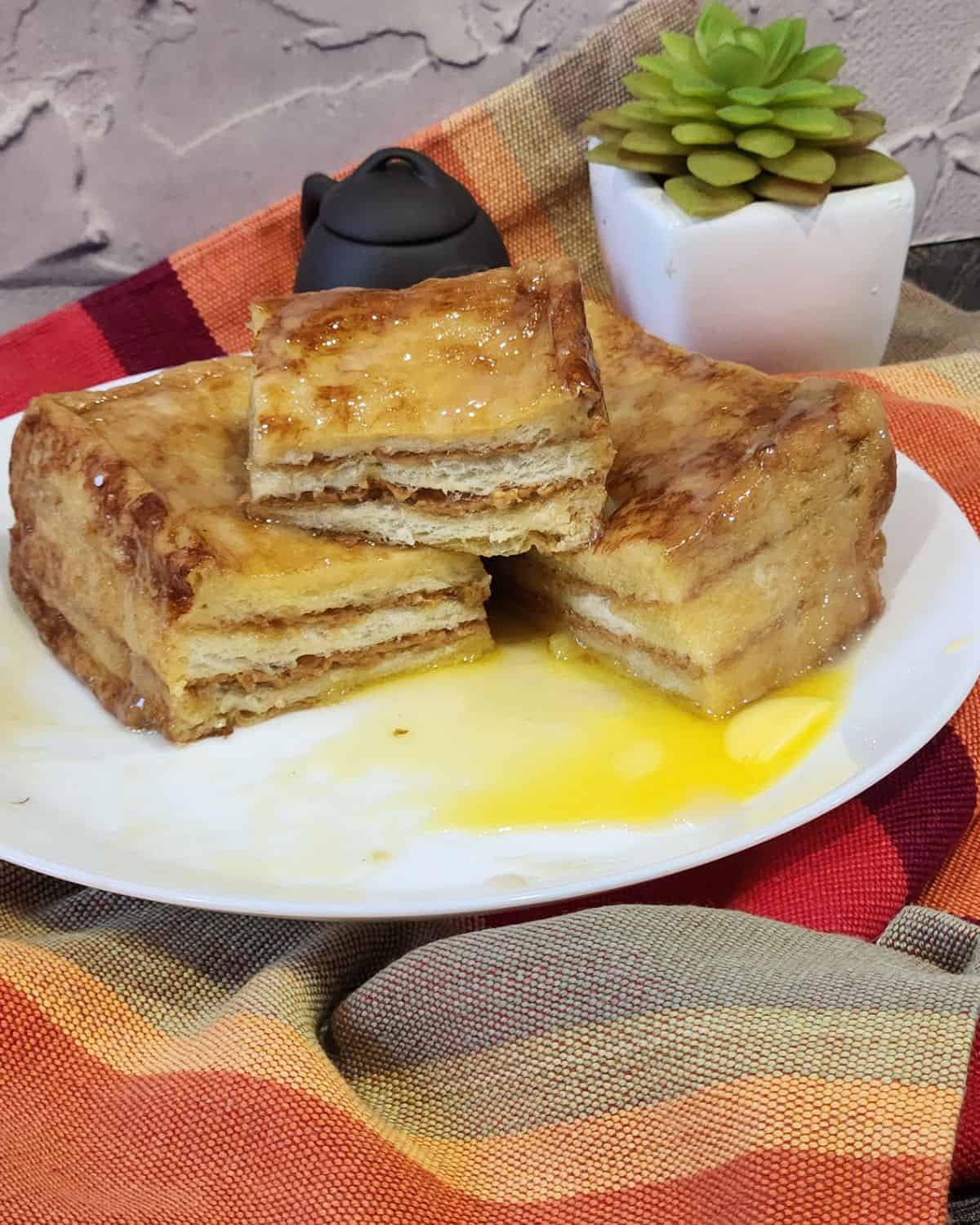 Hong Kong French toast sliced into 4 pieces with melted butter on the plate.