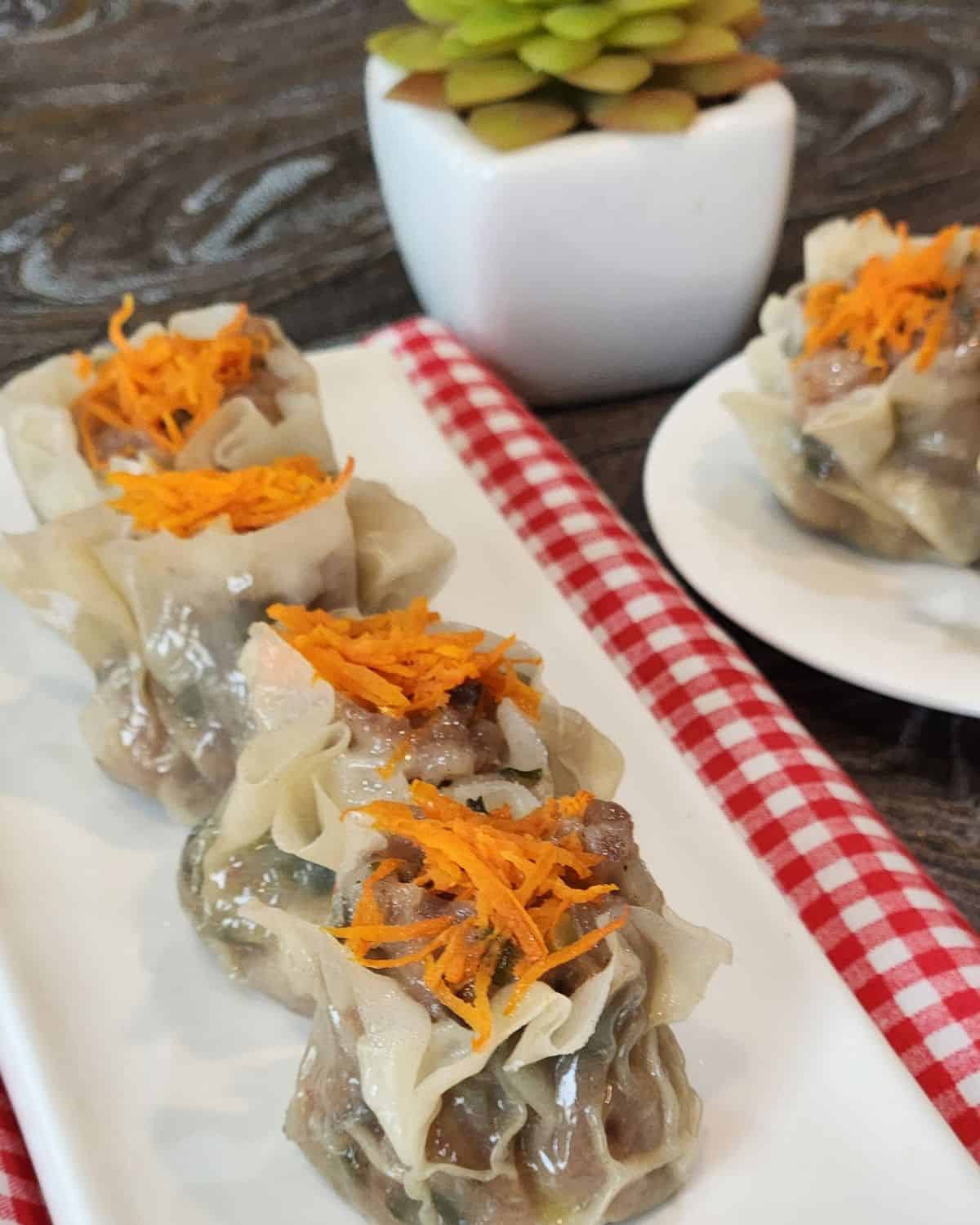 Shao mai or shu mai lined on a rectangular plate.