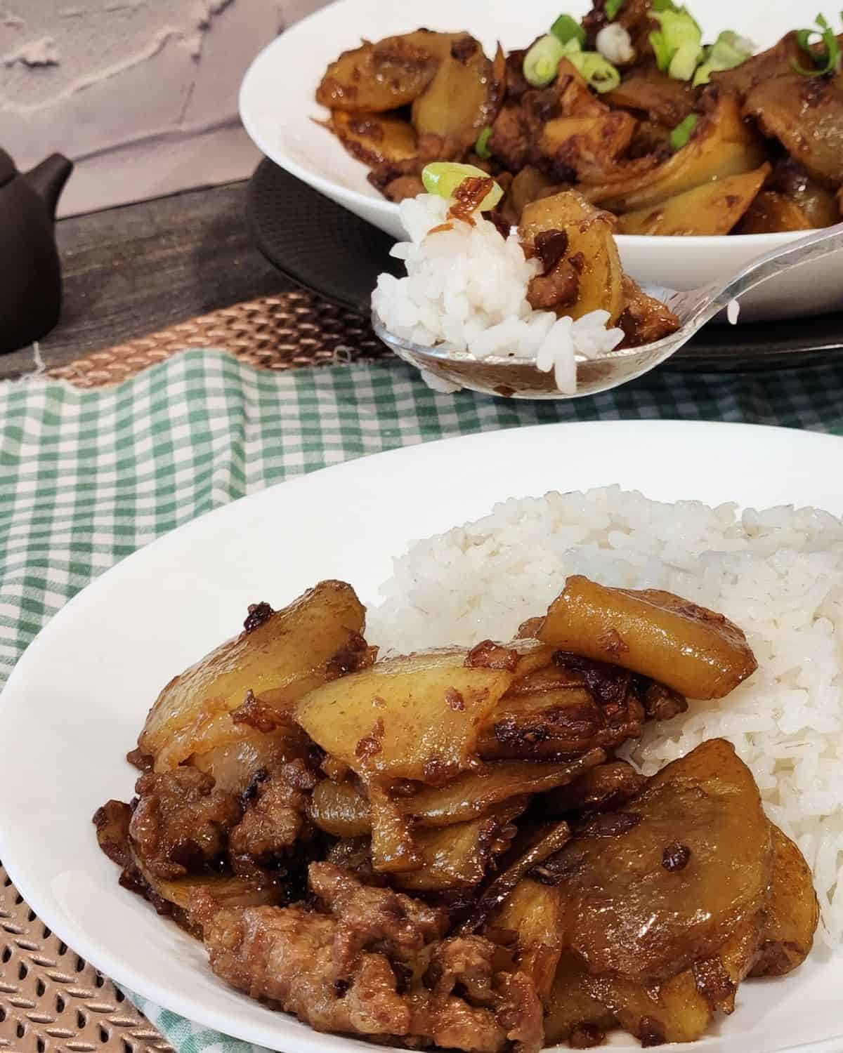 A scoop of rice and ground pork stir fry with potatoes. 