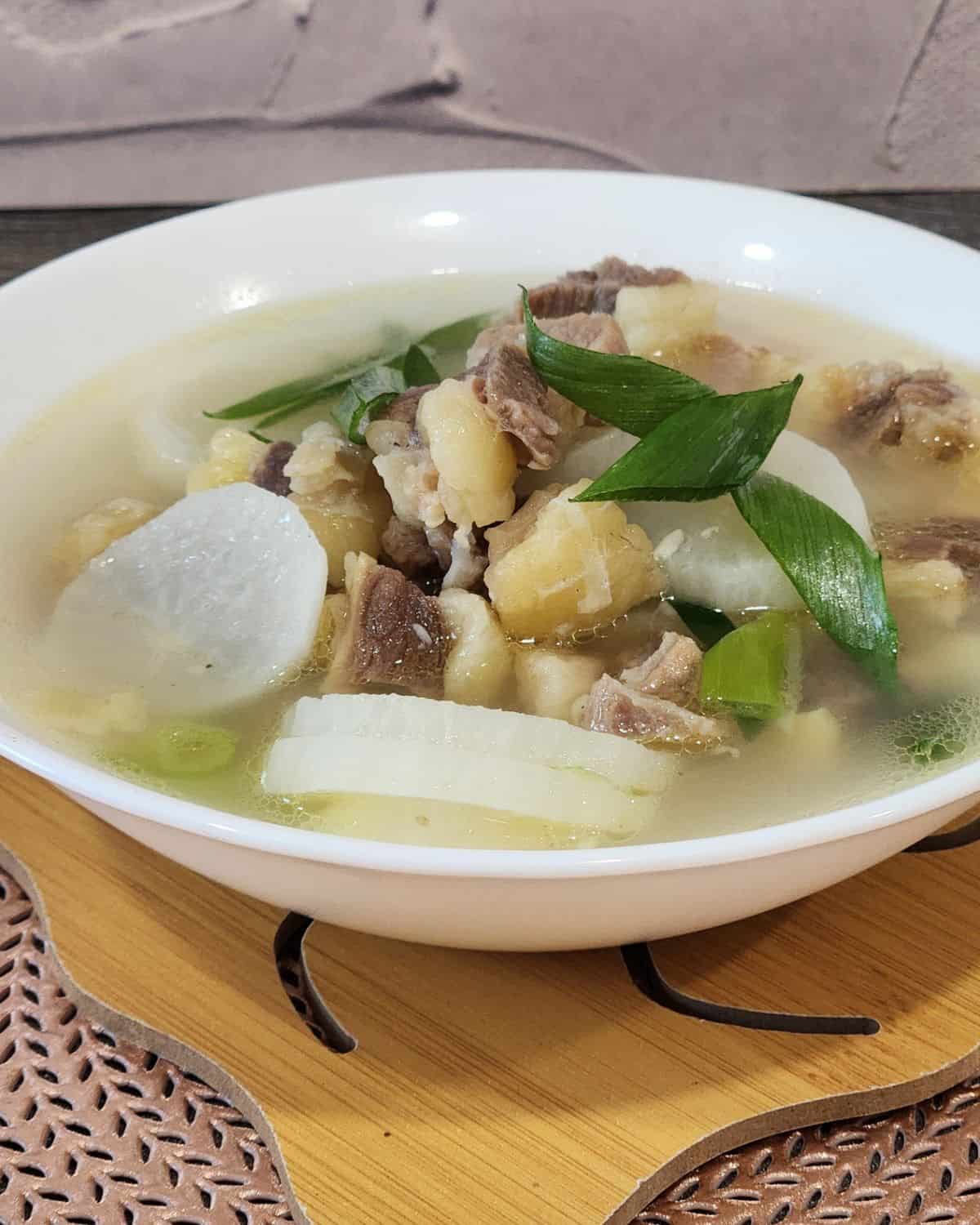 A bowl of Korean beef soup with radish and green onion.