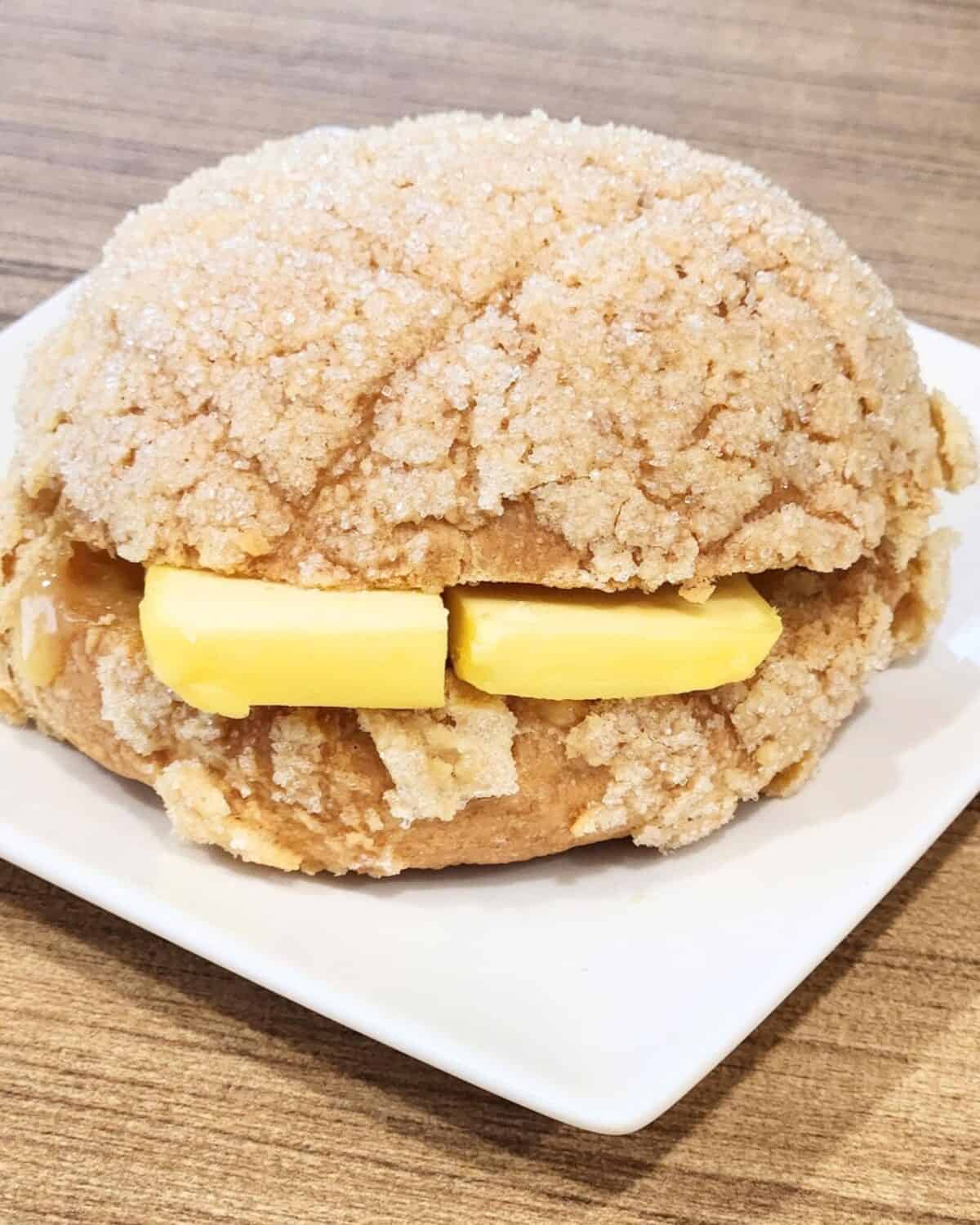 Melon pan served with a slice of thick butter and jam.