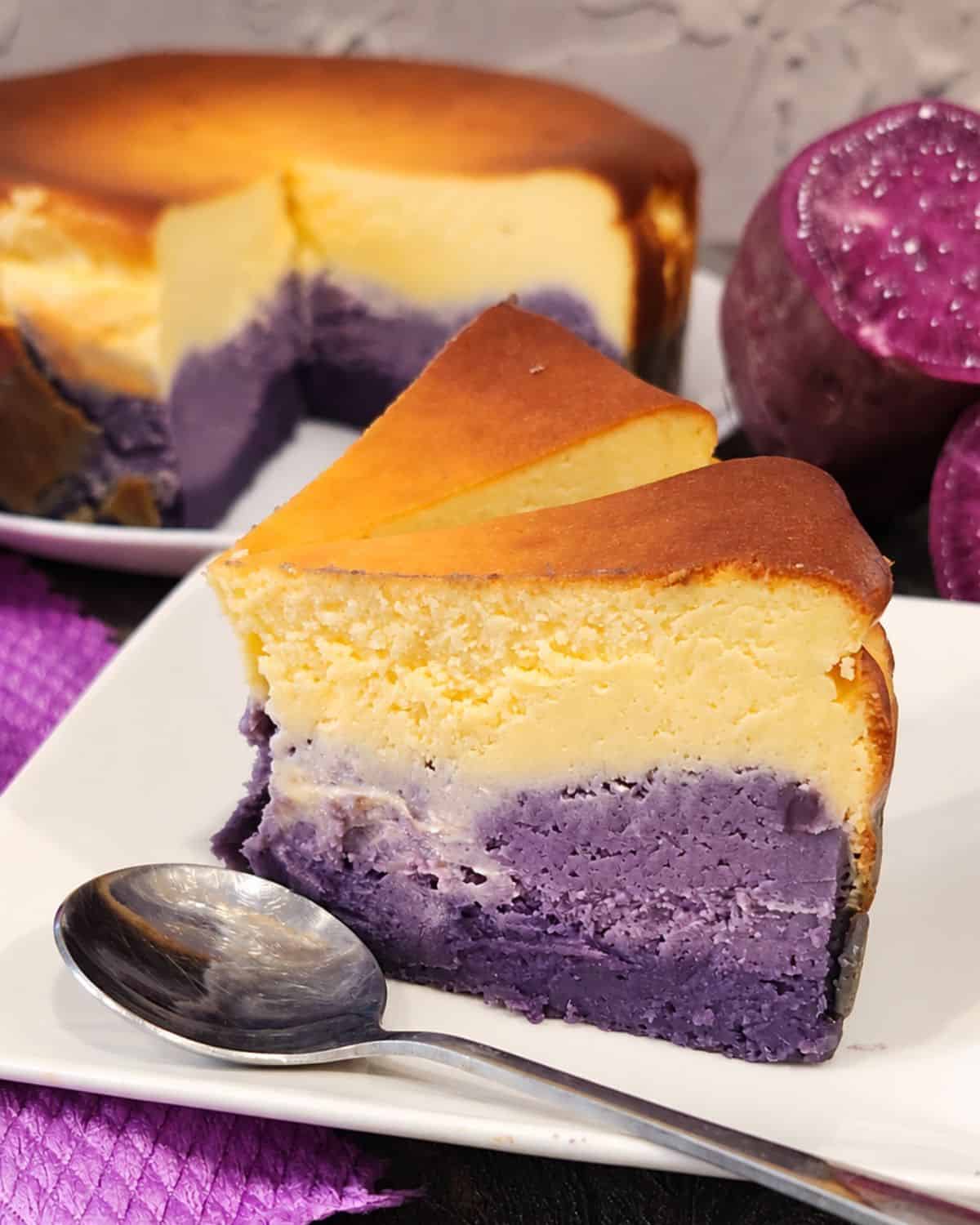 Two slices of ube cheesecake on a square plate.