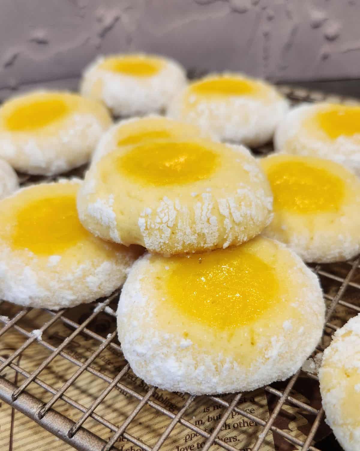 A few lemon curd cookies on a cooling rack.