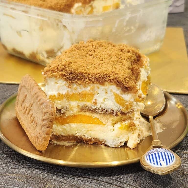 A piece of mango float with lotus biscoff on a golden plate.