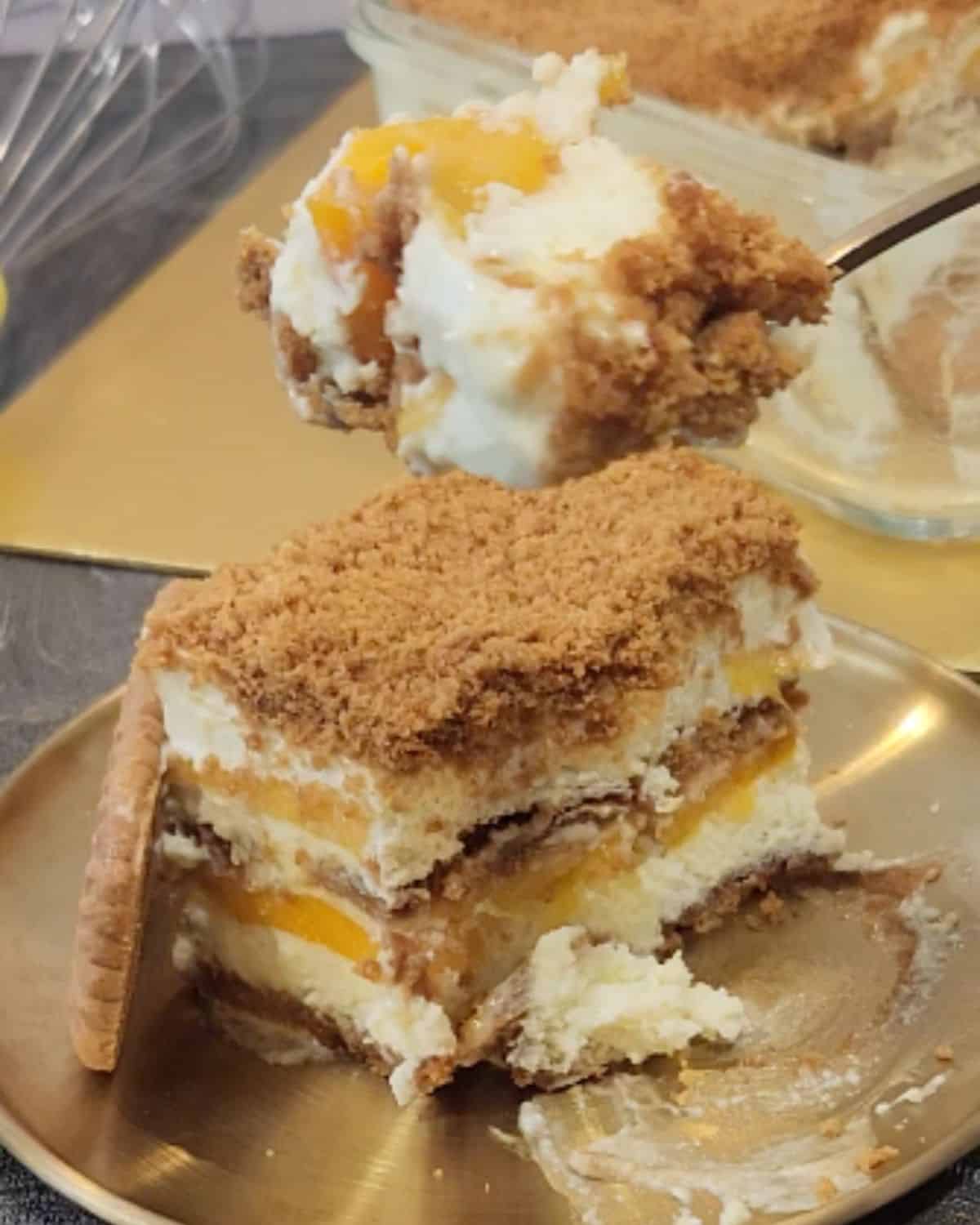 A dessert spoon with mango float on top of a golden plate.