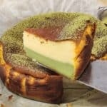 A spatula holding a slice of matcha cheesecake.