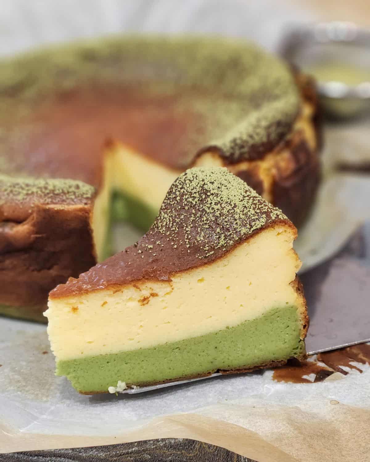 A slice of matcha cheesecake on a spatula.