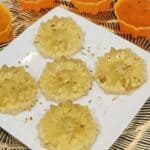 Five Osmanthus jelly on a plate with some osmanthus flowers sprinkled on it.
