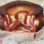 Red velvet cheesecake cut to show the zebra texture inside.