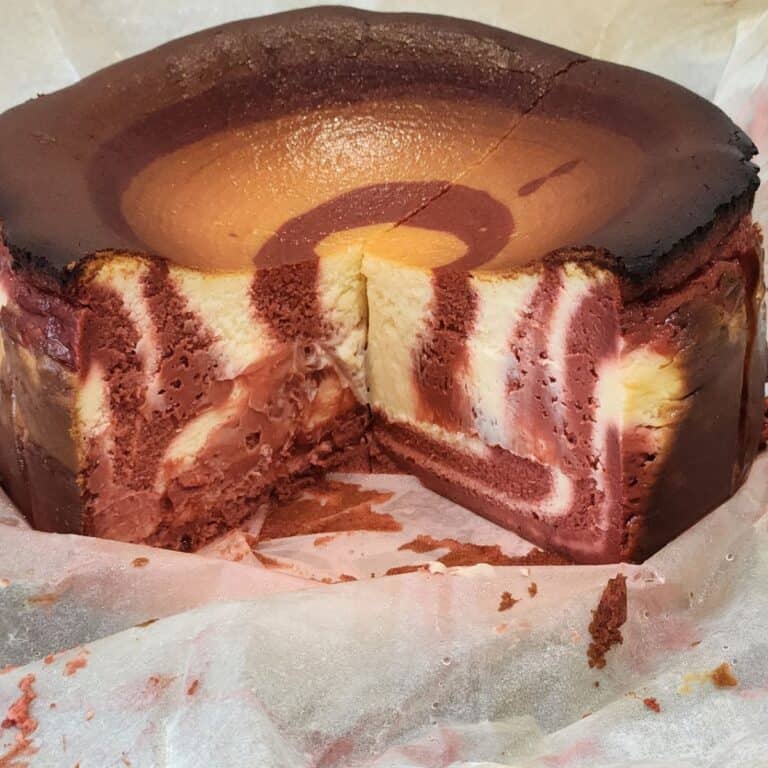 Red velvet cheesecake cut to show the zebra texture inside.