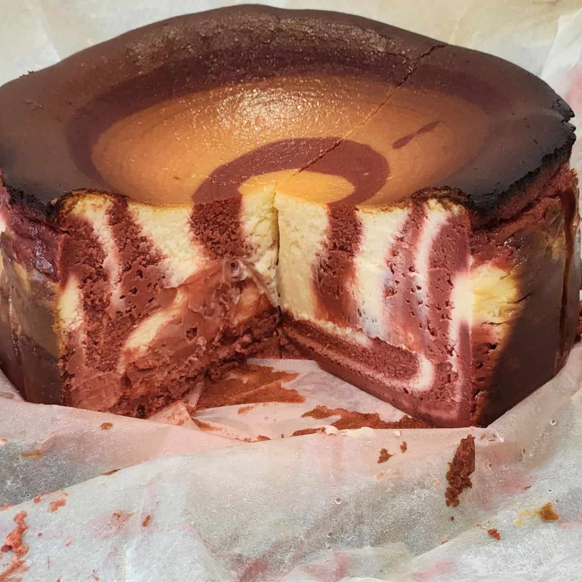 Red velvet cheesecake cut to show the zebra texture inside.